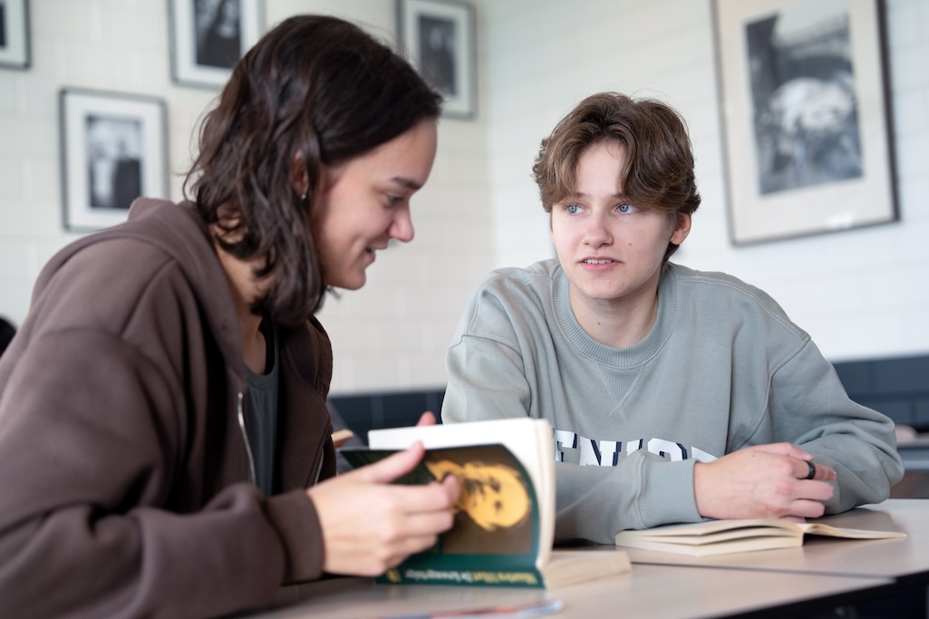 Leerlingen lezen boek in lokaal