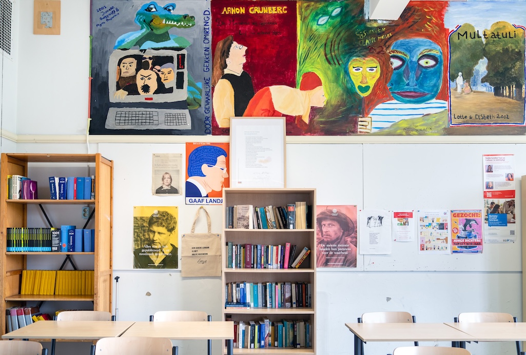 Klaslokaal met posters en boekenkast