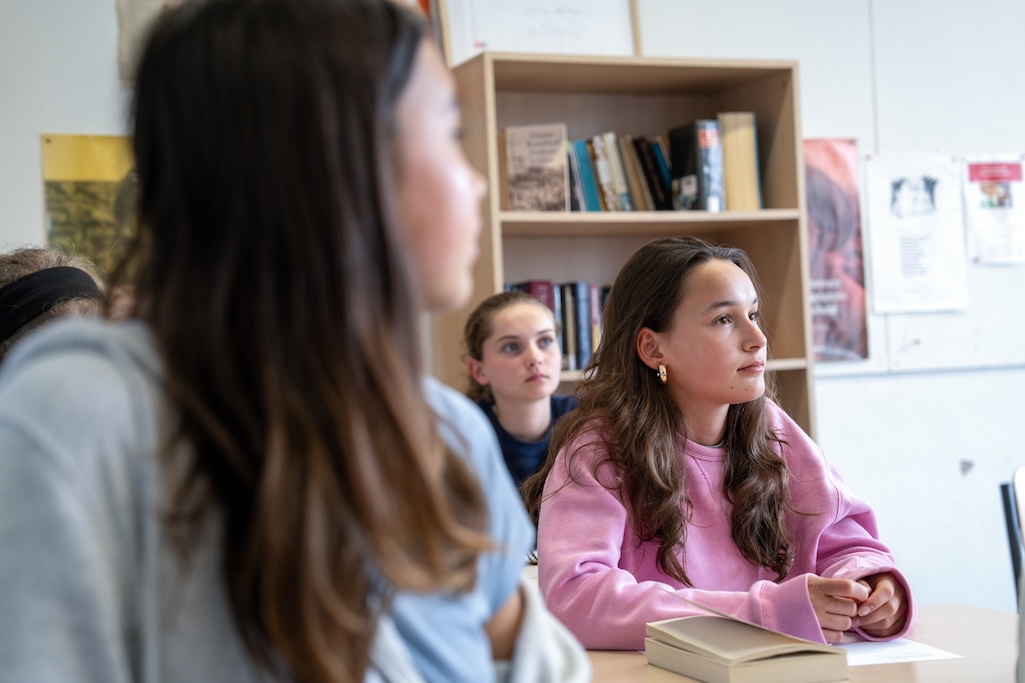 Leerlingen in de klas met pastelkleurige hoodies aan