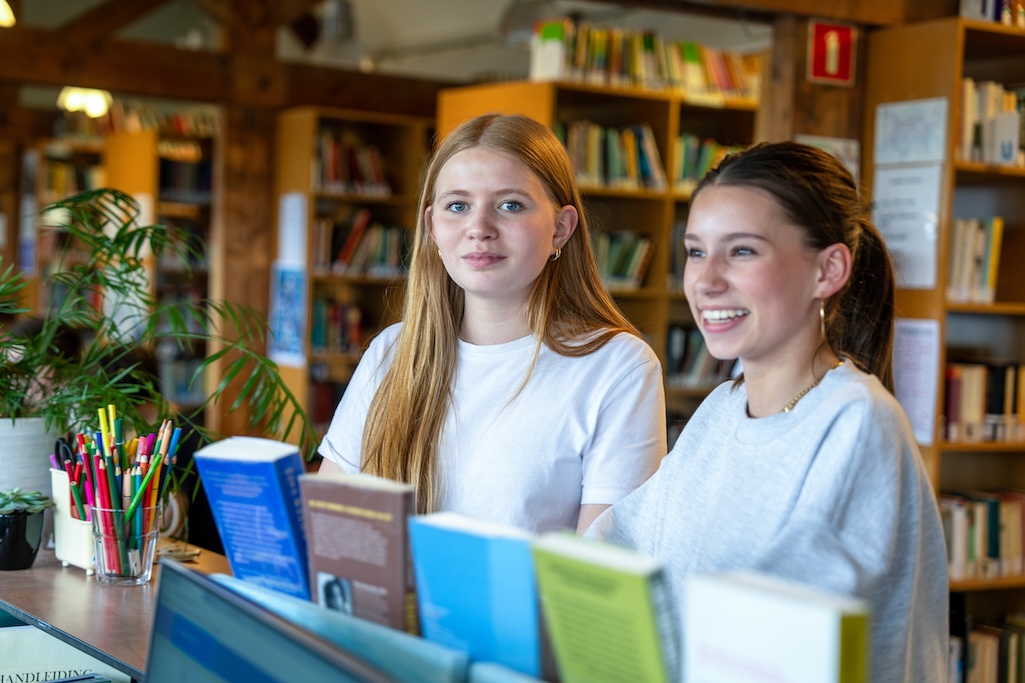 twee leerlingen met rijtje boeken