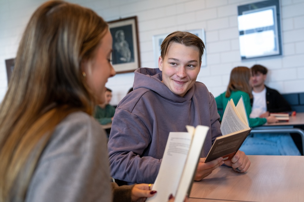 Twee leerlingen in gesprek met boeken