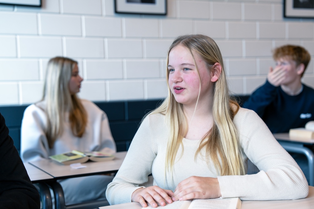 Leerling aan tafel met boek